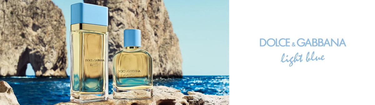 Two Dolce & Gabbana Devotion perfume bottles displayed outdoors with a scenic sunset background.