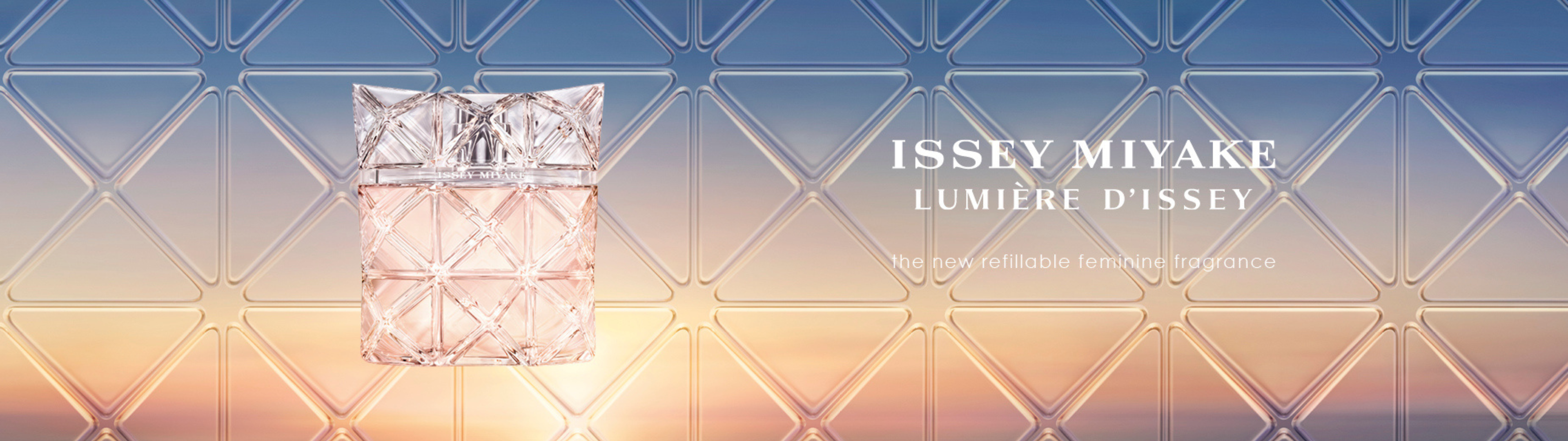 Two Issey Miyake perfume bottles beside a yellow flower on driftwood in water, luxury fragrance