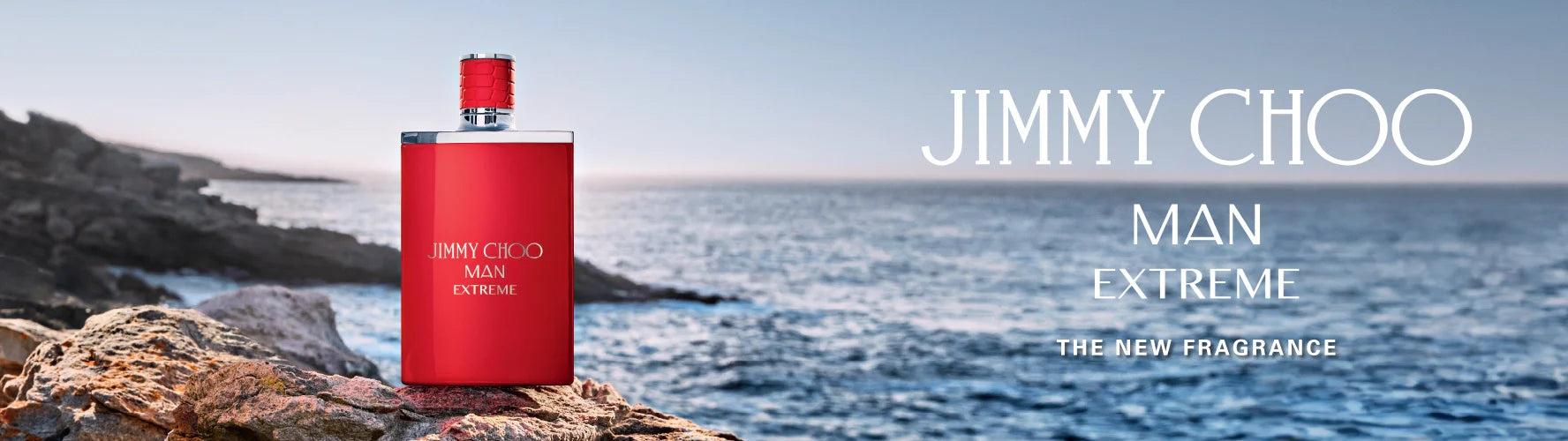 Red Jimmy Choo Man Extreme perfume bottle on rocky shore by the sea, new fragrance promotion
