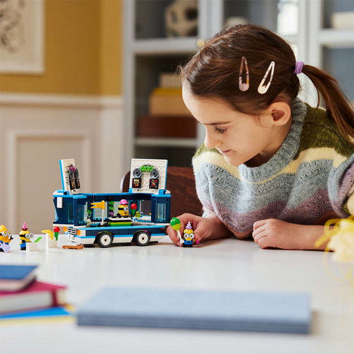 Girl playing with Minions LEGO toy set on a table in a cozy room, Sundora Bangladesh